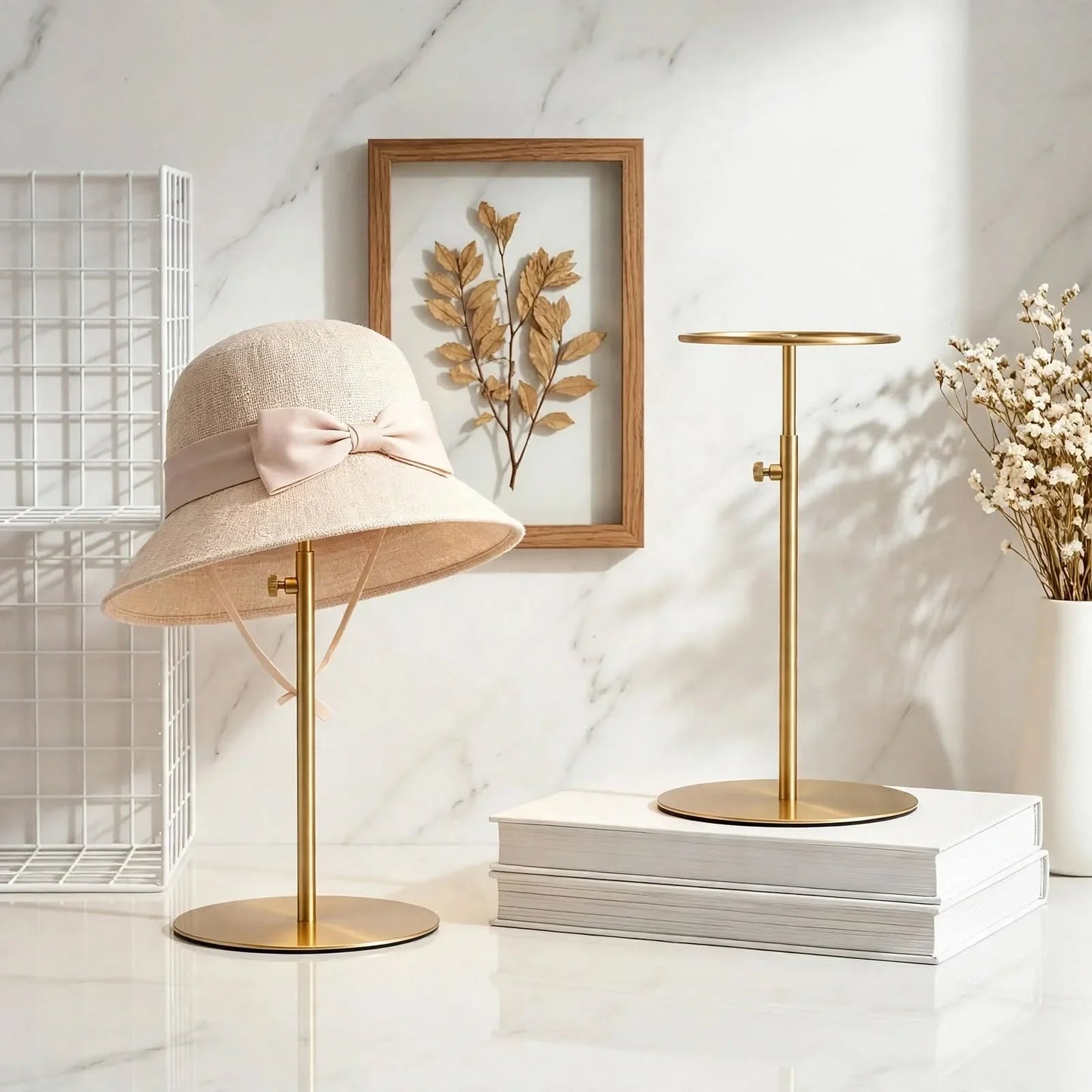 Beige straw sun hat with a bow on a gold metal hat stand against a marble background